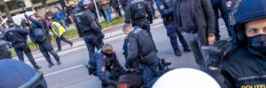 Götz Kubitschek (rechts) zwischen Polizist*innen, der durch einen Glasflaschenwurf verletzte identitäre Kader am Boden von der Polizei festgehalten (Foto: Presseservice Wien)