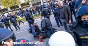 Götz Kubitschek (rechts) zwischen Polizist*innen, der durch einen Glasflaschenwurf verletzte identitäre Kader am Boden von der Polizei festgehalten (Foto: Presseservice Wien)