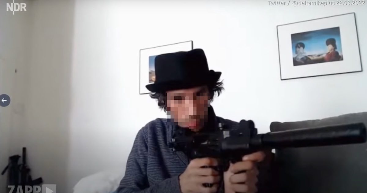 Manuel M. posiert mit einer Waffe (Attrappe?) und löst damit im März 2022 eine Razzia samt Anzeige nach dem Waffengesetz aus (Screenshot ZAPP)