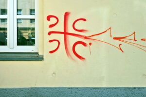 Die vier C stehen für „Samo sloga Srbina spasava“ (de: Nur Einigkeit rettet die Serben). Das nationalistisch aufgeladene „serbische Kreuz“ ist eine Vereinfachung des serbischen Wappens. (Quelle: balkanstories.net, 16.8.26)