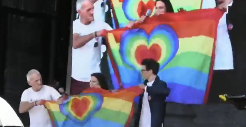 Mittas, Klauninger und Mann mit Kilt beim Zerreissen der Regenbogenfahne
