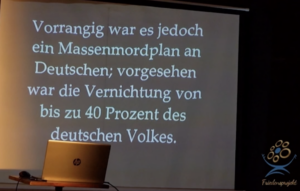 Seminar zum "Veritas-Begleiter", Fake-Infos auf der Leinwand: "Vorrangig war es jedoch ein Massenmordplan an Deutschen; vorgesehen war die Vernichtung von bis zu 40 Prozent des deutschen Volkes." (Screenshot eines Imagefilms von "Friedensprojekt")